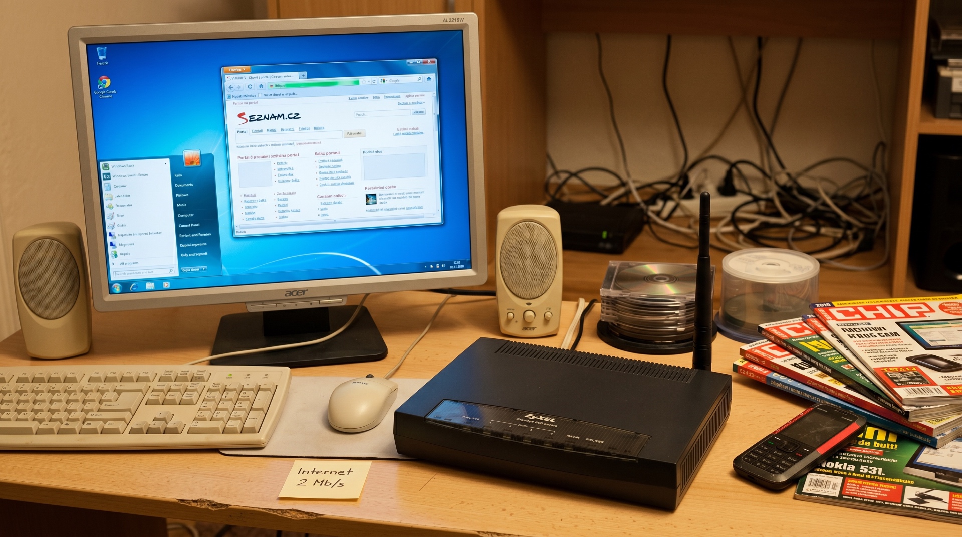Domácí pracovní stůl s PC, Wi-Fi routerem ZyXEL a mobilem Nokia – internet 2 Mb/s, rok 2010